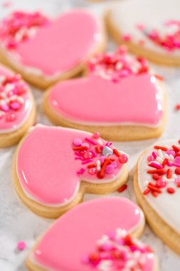 Sevgililer Günü için pembe ve beyaz kraliyet kremalı kalp şeklinde kurabiyeler..