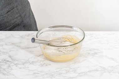 Islak ve kuru malzemelerle bardakta çırpma kabını karıştırıp limonlu haşhaşhaşlı kek pişirmek..