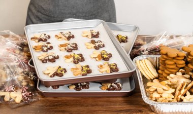 Dikkatlice paketlenmiş Noel kurabiyeleri, çikolataya batırılmış ve şeffaf selofan ambalajla sunulmuş, bayram hediyesi olarak mükemmel..