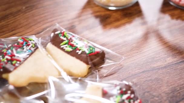 Тщательно Упаковывая Рождественское Печенье Полуокунутое Шоколад Представленное Прозрачной Целлофановой Упаковке — стоковое видео