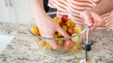 Gösterişli, modern bir mutfakta, genç bir adam dikkatlice akşam yemeğini hazırlar. Şimdiki görevi cam bir kasede küçük gökkuşağı patateslerini dikkatlice tatlandırmak ve önlerinde lezzetli bir yemek sözü vermek..