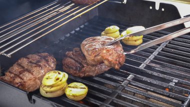Açık hava gaz ızgarası iyi bir amaç için kullanılıyor. Pirzola bifteği ve soğan halkalarının sesi ve aromasıyla cızırdıyor..