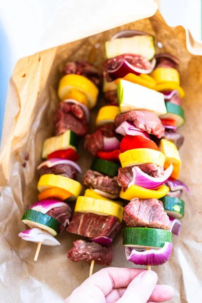 用牛肉和新鲜蔬菜包裹着的生肉串在烤架上等待烧烤 — 图库照片
