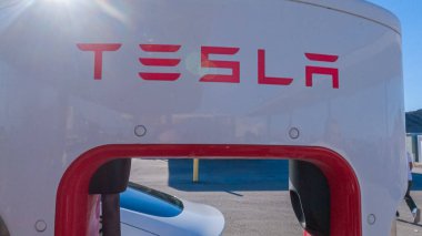 Baker, California, ABD-3 Aralık 2022-Gün boyunca Tesla bir süper şarj istasyonunda yüksek hızlı şarj altyapısını uygun ve verimli bir şekilde kullanan bir Tesla aracı görüldü.