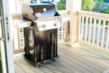 Denver, Colorado, ABD-Haziran 3, 2023-Webers gösterişli, kapalı iki ocaklı ızgara, düşünceli bir şekilde bir banliyö evinin balkonuna yerleştirilmiş, enfes bir açık hava pişirme deneyimi için hazır.