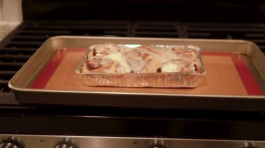 Fırından yeni çıkmış, tarçınlı çörek silikon bir hasırın üzerinde serinliyor, kremaları mutfak ışıklarının altında parlıyor..