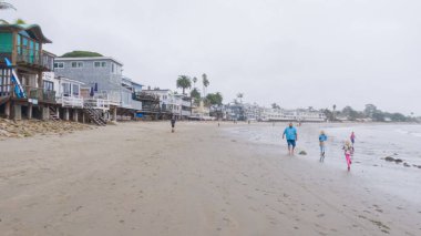 Los Angeles, California, ABD-4 Aralık 2022-POV-Yürürken Miramar Sahili, California kıyılarında bulutlu kış gökyüzü sakin ve yansıtıcı bir atmosfer yaratır..