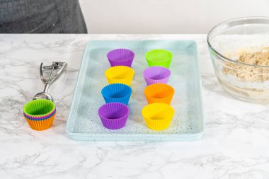 Hamur kepçesiyle top kek hamuru pişirip silikon kek dilimlerinden limon haşhaşlı çöreğe dönüştürüyor..