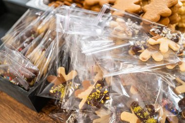 Dikkatlice paketlenmiş Noel kurabiyeleri, çikolataya batırılmış ve şeffaf selofan ambalajla sunulmuş, bayram hediyesi olarak mükemmel..