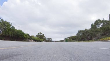 Araç, bulutlu bir kış gününde Morro Bay, Kaliforniya sokaklarında yol alır. Hava karamsar ve sakin bulutlu gökyüzü büyüleyici binalara yumuşak bir ışık ve sessiz