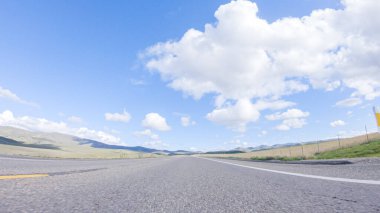 Açık bir kış gününde, bir araba, Santa Maria, California yakınlarındaki 101. Otoyol boyunca yeşil ve altın renkli bir karışımla çevrili, parlak mavi bir gökyüzünün altında sorunsuzca seyahat eder..