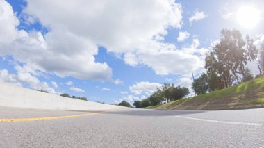 Açık bir kış gününde, bir araba, Santa Maria, California yakınlarındaki 101. Otoyol boyunca yeşil ve altın renkli bir karışımla çevrili, parlak mavi bir gökyüzünün altında sorunsuzca seyahat eder..