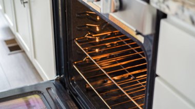 Modern bir mutfak ortamında, genç bir adam şu anda fırında baharatlı gökkuşağı patatesi kızartılarak lezzetli bir yemeğe doğru önemli bir adım atıyor..