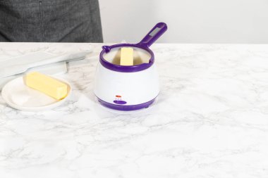 Cam kasenin içindeki malzemeleri birleştirmek, lezzetli bir vanilyalı kek hazırlamak için ustalıkla çırpmak..