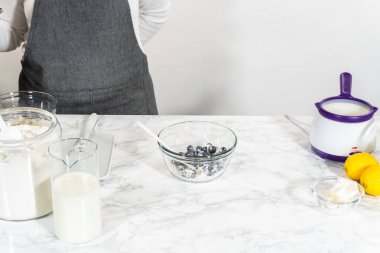 Cam bir kasenin içindeki bileşenleri birleştirmek, bir çırpıcıyla karıştırmak, limonlu-yabanmersinli kek hazırlamak..