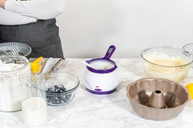 Kek kalıbı için yapışmaz bir yüzey oluşturmak için sebze kısaltma nazikçe eritilir ve unla harmanlanır..