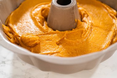 Pasta hamurunu kek tepsisine dökerek nefis bir ev yapımı balkabağı pastası yapmaya hazır..