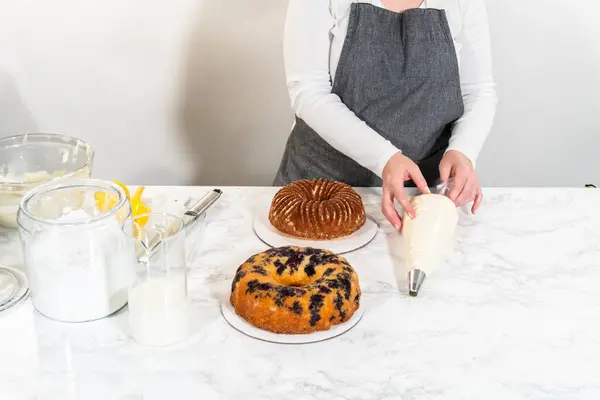 这次愉快烘焙之旅的最后一步是在冷却的面包蛋糕上 巧妙地在上面铺上丝滑的奶油奶酪奶油 营造出一种不可抗拒的美味 — 图库照片