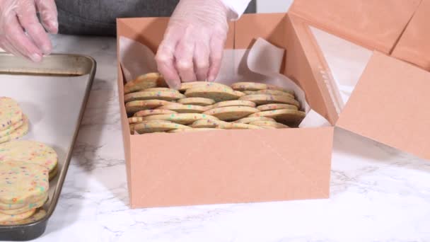 精密に 女性は慎重に砂糖クッキーを配置しています 生地混合スパイクでいっぱい 素朴な茶色の紙箱に — ストック動画