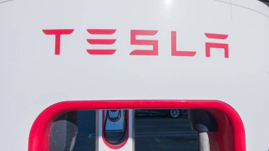 Baker, California, ABD-3 Aralık 2022-Gün boyunca Tesla bir süper şarj istasyonunda yüksek hızlı şarj altyapısını uygun ve verimli bir şekilde kullanan bir Tesla aracı görüldü.