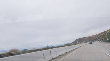 Kederli, bulutlu bir kış gününde, California, Rincon Sahili yakınlarında 101. Otoyol 'da araba sürüyorum..