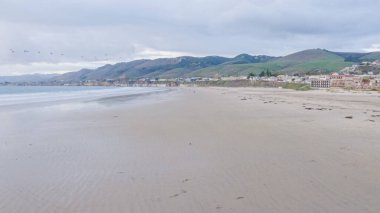 Güneş batarken Pismo Sahili, içi boş, kumlu kumlu, altın renklerle dolu büyüleyici bir kış harikalar diyarına dönüşüyor. Dalgaların huzur veren sesleri,