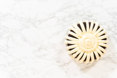 Düz yatıyordu. Hassasiyetle, çikolatalı kek dikkatlice tavadan çıkartılır. Lezzetli krem peynirle süslenir ve lezzetli bir ziyafet yaratır..