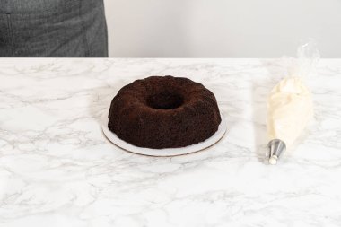 Hassasiyetle, çikolatalı kek dikkatlice tavadan çıkartılır. Lezzetli krem peynirle süslenir ve lezzetli bir ziyafet yaratır..