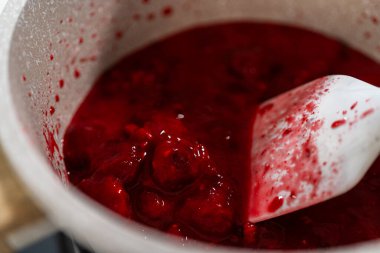 Küçük bir tencerede, ölçülen malzemeler bir araya gelir. Lezzetli ahududu kekinin kaynatılmasına ve lezzetli tatlarla doldurulmasına izin verir..