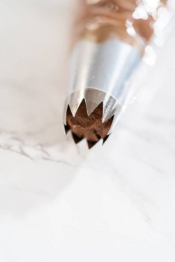 Çikolata kreması özenle bir torbaya aktarılıyor. Lezzetli kekleri süslemeye hazır..