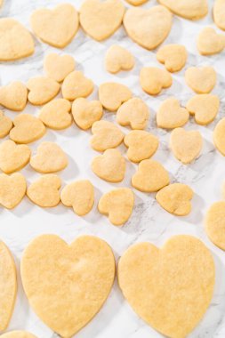 Sevgililer Günü için pembe ve beyaz kraliyet kremalı kalp şeklinde kurabiyeler..