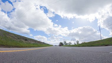 Açık bir kış gününde, bir araba, Santa Maria, California yakınlarındaki 101. Otoyol boyunca yeşil ve altın renkli bir karışımla çevrili, parlak mavi bir gökyüzünün altında sorunsuzca seyahat eder..
