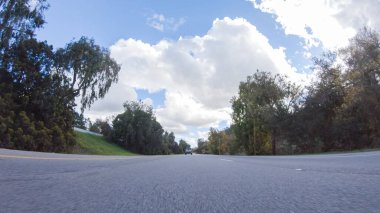 Açık bir kış gününde, bir araba, Santa Maria, California yakınlarındaki 101. Otoyol boyunca yeşil ve altın renkli bir karışımla çevrili, parlak mavi bir gökyüzünün altında sorunsuzca seyahat eder..