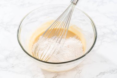 Islak ve kuru malzemelerle bardakta çırpma kabını karıştırıp limonlu haşhaşhaşlı kek pişirmek..