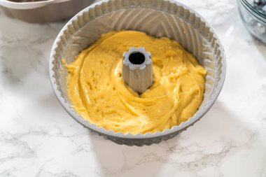 Pasta hamurunu önceden yağlanmış bohçaya nazikçe aktarmak başarılı bir pişirme işlemi için zemin hazırlıyor..