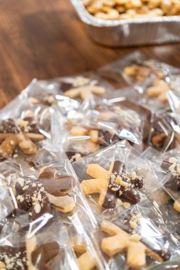 Dikkatlice paketlenmiş Noel kurabiyeleri, çikolataya batırılmış ve şeffaf selofan ambalajla sunulmuş, bayram hediyesi olarak mükemmel..