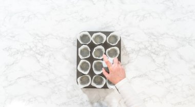 Düz yatıyordu. Tarçınsız kek pişirmek için kek tepsisini kağıt lalelerle kaplamak..