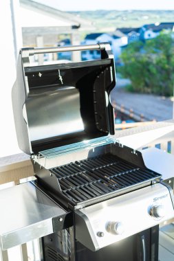 Denver, Colorado, ABD-Haziran 3, 2023-Webers iki ocaklı ızgara, kapağı davetkar bir şekilde açık, bir banliyö evinin balkonunda düşünceli bir şekilde hazırlanmış,