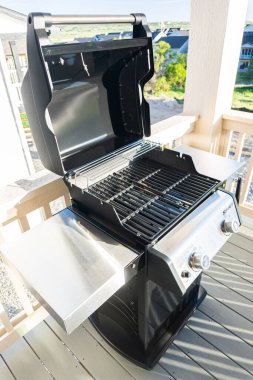 Denver, Colorado, ABD-Haziran 3, 2023-Webers iki ocaklı ızgara, kapağı davetkar bir şekilde açık, bir banliyö evinin balkonunda düşünceli bir şekilde hazırlanmış,