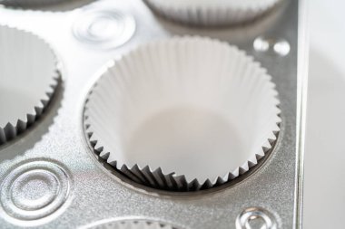 Cupcake folyoları titizlikle hem çikolata hem de vanilya hamuruyla dolduruluyor. Lezzetli çeşitlilikte doğum günü kekleri pişirmek için zemin hazırlıyorlar..