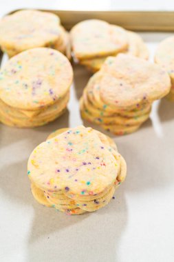 Büyük miktarda şekerli kurabiye düzgünce pişirme tepsisine istiflenmiş, paketlerinin kırsal kahverengi karton kutulara konmasını bekliyor..