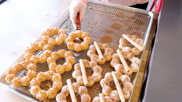 Metal tepsilerde çeşitli malzemelerle taze pişmiş mochi çörekleri eşsiz şekillerini ve şekerli kaplamalarını vurguluyor..