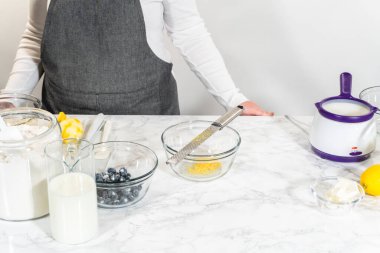 Cam bir kasenin içindeki bileşenleri birleştirmek, bir çırpıcıyla karıştırmak, limonlu-yabanmersinli kek hazırlamak..