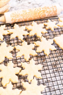 Lezzetli kar tanesi şekilli şekerli kurabiyeleri rafta soğutup onları Noel hediyelerine hazırlıyorum..