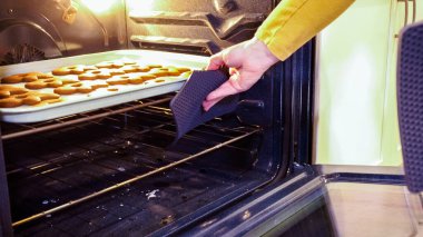 Scrumptious gingerbread cookies getting baked to perfection in a gas oven, filling the kitchen with warm, aromatic holiday bliss. clipart