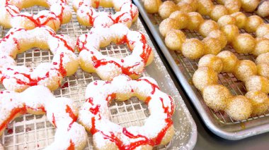 Metal tepsilerde çeşitli malzemelerle taze pişmiş mochi çörekleri eşsiz şekillerini ve şekerli kaplamalarını vurguluyor..