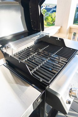 Gösterişli, açık kapaklı, çift ocaklı ızgara kullanıma hazır, banliyödeki bir evin balkonunda konumlandırılmış, nefis bir yemek pişirme deneyimi vaat ediyor..