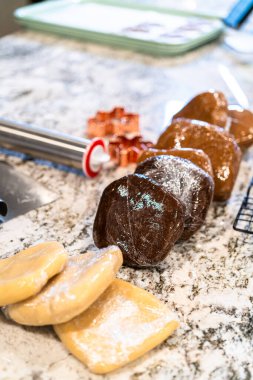 Modern beyaz bir mutfakta, bu dondurulmuş zencefilli ekmek ve şekerli kurabiye hamuru porsiyonları rulo haline getirilip lezzetli ikramlar haline getirilmeye hazırdır..