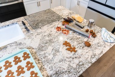 Çağdaş beyaz bir mutfakta zencefilli kurabiye hamuru ustalıkla sarılır ve nefis bir tatil ziyafeti için zemin hazırlar..