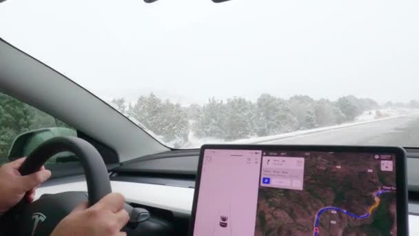 2022年12月7日在美国科罗拉多州丹佛市的一辆特斯拉电动车中 一位司机在一场冬季风暴中驾轻就熟地穿越了西部五彩斑斓的雪地 — 图库视频影像